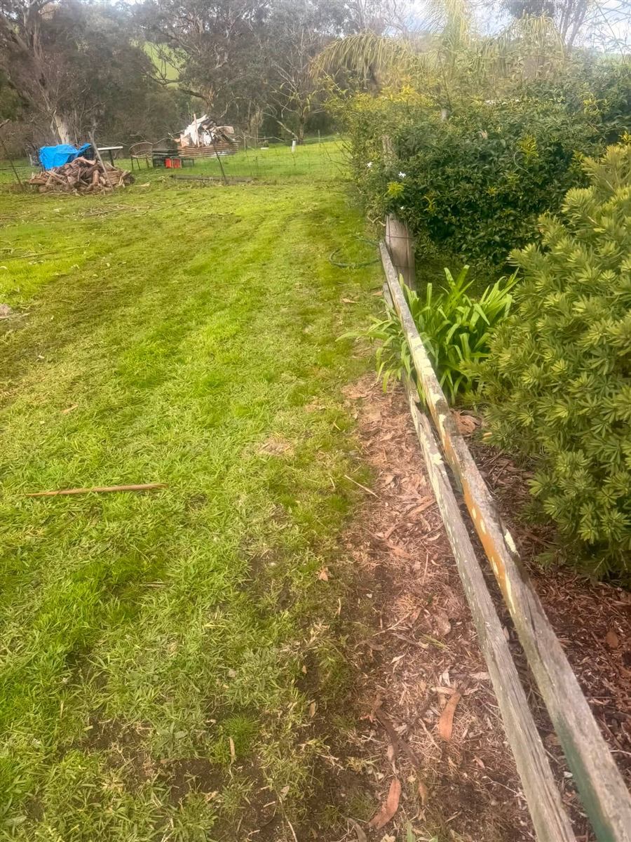 Lawn mowed along a timber sleeper garden edge in Carrickalinga